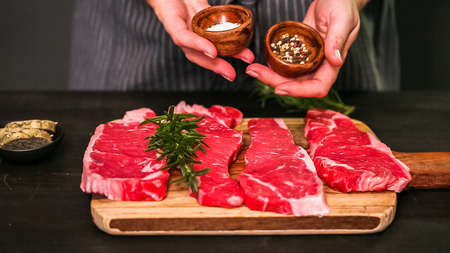 Raw New York strip steaks on a wood cutting board.の写真素材