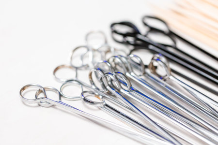 Steel and wood skewers on a white painted wood background.の写真素材