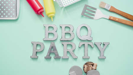 Metal BBQ Party sign with grilling tools on blue background.の写真素材