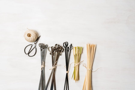 Steel and wood skewers on a white painted wood background.の写真素材