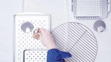 Variety of BBQ grill trays on a white painted wood background.の写真素材