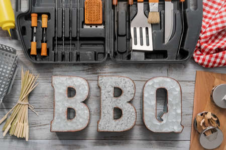 BBQ cooking set in the case on the wood background.の写真素材
