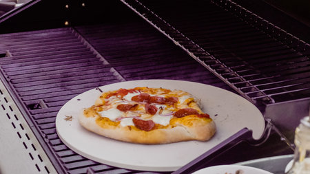 Cooking pizza on outdoor gas grill.