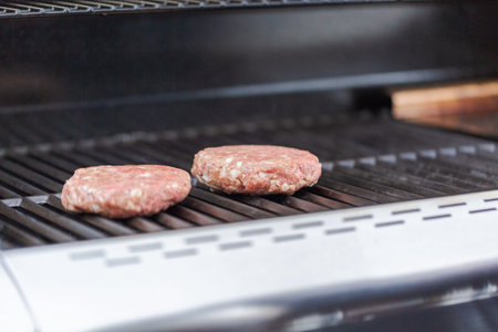 Cooking classic burgers on outdoor gas grill in the Summer.