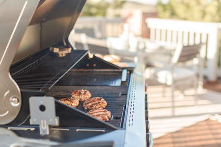 Grilling classic burgers on outdoor gas grill in the Summer.の写真素材