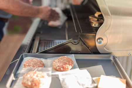 Grilling classic burgers on outdoor gas grill in the Summer.