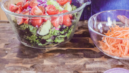 Mixing fresh salad with Spring mix greens.の写真素材