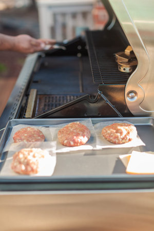 Grilling classic burgers on outdoor gas grill in the Summer.