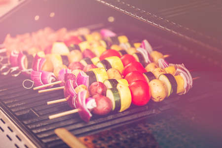 Step by step. Grilling veggie skewers and chicken kebabs on outdoor gas grill.の写真素材