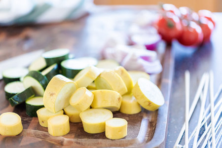 Slicing fresh organic vegetables for veggie kebabs.の写真素材