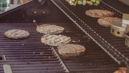 Step by step. Cooking burgers on outdoor gas grill in the Summer.