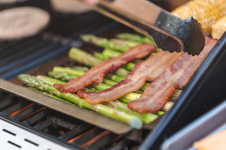 Step by step. Grilling asparagus on outdoor gas grill.の写真素材