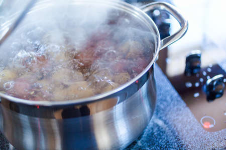 Boiling little gold and red potatoes in large cooking pot.の写真素材