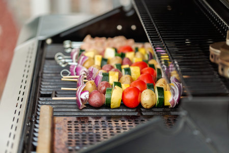 Step by step. Grilling veggie skewers and chicken kebabs on outdoor gas grill.