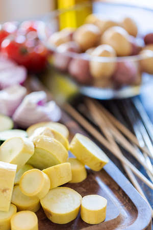 Slicing fresh organic vegetables for veggie kebabs.の写真素材