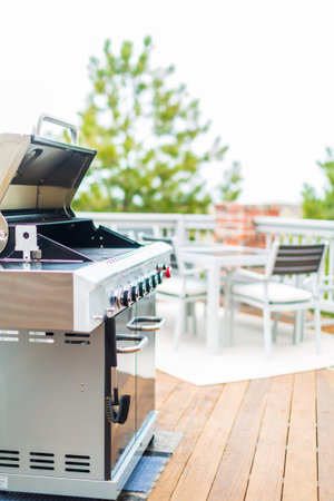 Six burner outdoor gas grill with open lid on backyard.の写真素材
