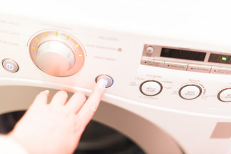 Doing laundry in laundry room of modern single family house in suburbs.