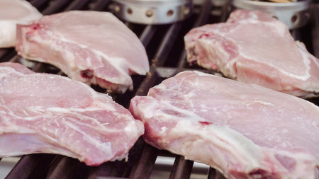 Cooking pork chops with pineapples on gas grill in the Summer.