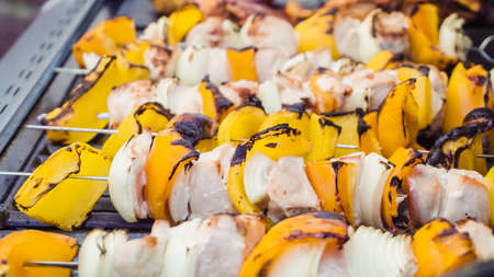Step by step. Cooking chicken shish kabobs with bell peppers and yellow onions on outdoor gas grill.の写真素材