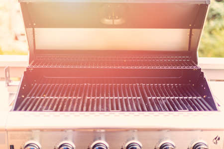 Six burner outdoor gas grill with open lid on backyard.の写真素材