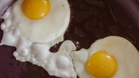 Cooking sunny-side up farm fresh eggs for breakfast.の写真素材