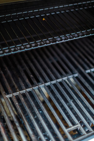 Dirty cast iron cooking grates on 6 burner outdoor gas grill.