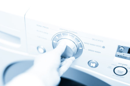 Doing laundry in laundry room of modern single family house in suburbs.