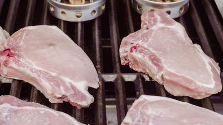 Cooking pork chops with pineapples on gas grill in the Summer.の写真素材