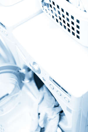 Doing laundry in laundry room of modern single family house in suburbs.の写真素材