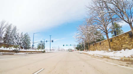 Driving on suburban road after Spring snow storm.の写真素材