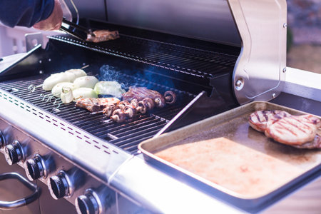 Grilling pork chops on gas grill in the Summer.