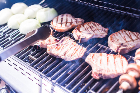 Grilling pork chops on gas grill in the Summer.
