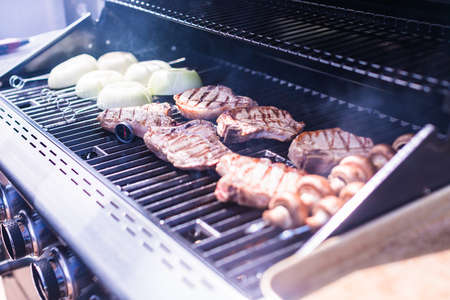 Grilling pork chops on gas grill in the Summer.の写真素材
