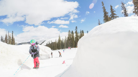 Denver, Colorado, USA-March 31, 2018-POV-Kids playing in snow castle on top of Alpine mountain.