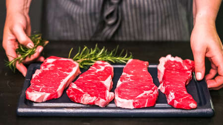Raw New York strip steaks on a wood cutting board.の写真素材
