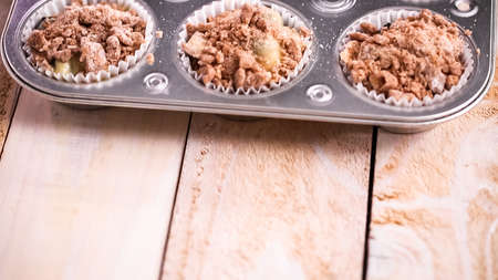 Scooping cinnamon and sugar topping on blueberry muffin batter.の写真素材