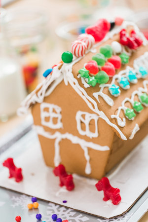 Kids decorating small gingerbread houses at the Christmas craft party.