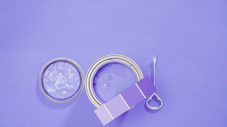 Opened metal paint can with violet paint and paint swatches.