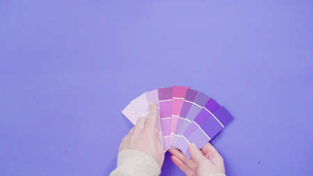 Hand holding paint swatches with shades of violet colors.の写真素材
