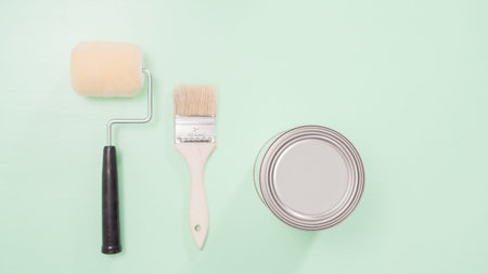 Paint brush and roller for house painting project.