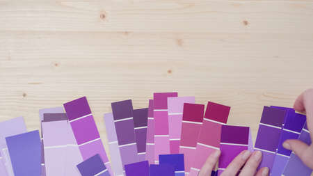 Variety of paint swatches with shades of purple pain on unfinished wooden background.の写真素材