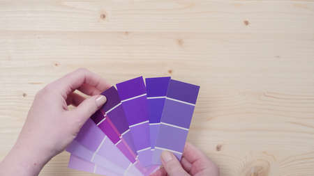 Variety of paint swatches with shades of purple pain on unfinished wooden background.の写真素材