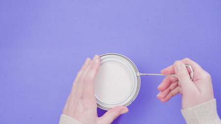Opening metal paint can with violet interior paint.の写真素材