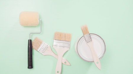 Paint brush and roller for house painting project.