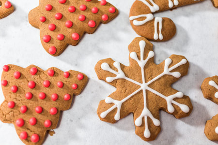 Decorating traditional gingerbread cookies with royal icing for Christmas.