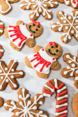 Decorating traditional gingerbread cookies with royal icing for Christmas.