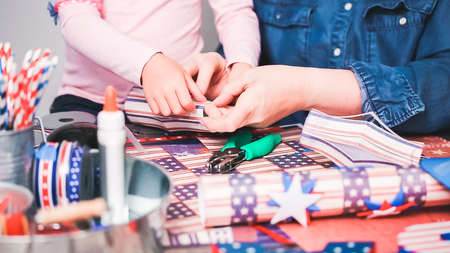 Step by step. Mother and daughter making paper firecrackers for July 4th celebration.の写真素材
