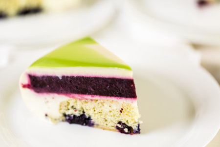 Sliced mousse cake with mirror glaze on the table.