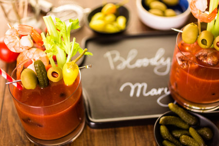Bloody mary cocktail garnished with olives, pickles, and cocktail shrimp.の写真素材