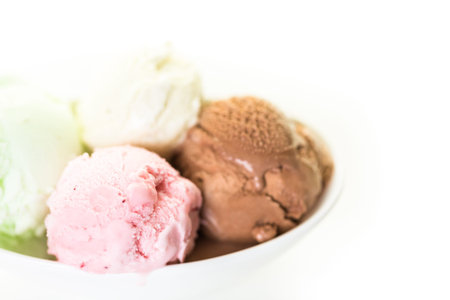 Variety of ice cream scoops in a white bowl.
